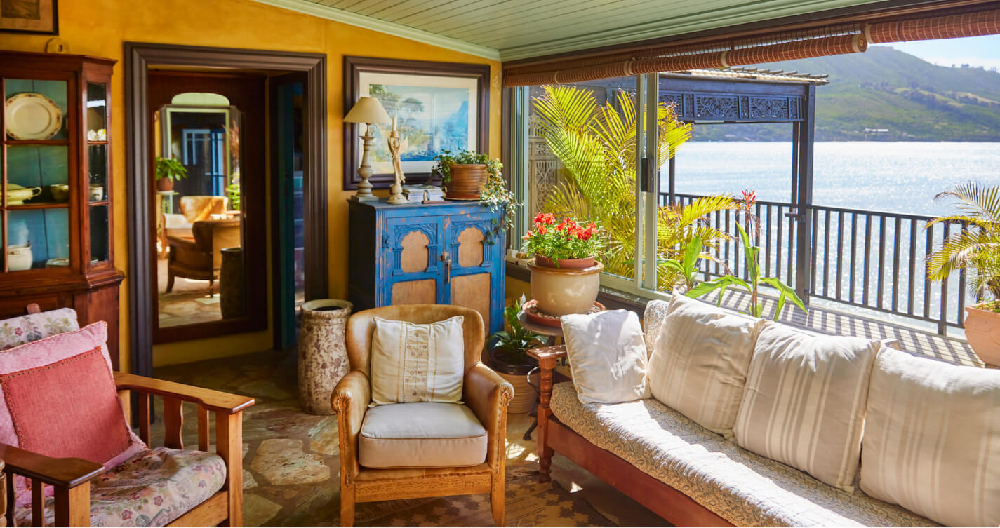 The Luxury Suite living room. It offers an exceptional sea view. Large sliding windows allow natural light and fresh air into the room. Healthy pot plants bring nature into the room. Comfortable looking couches create lots of space to relax.